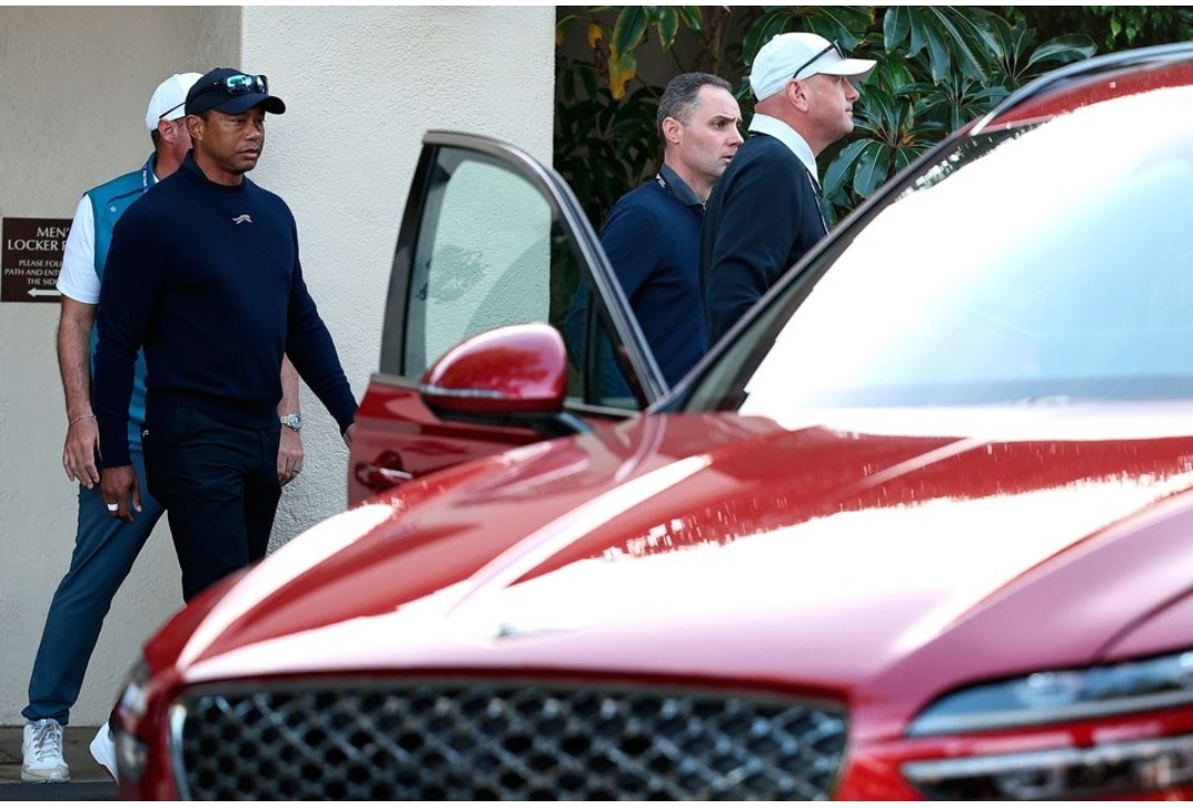 Tiger Woods leaves from the clubhouse after withdrawing from the tournament due to illness during the second round of