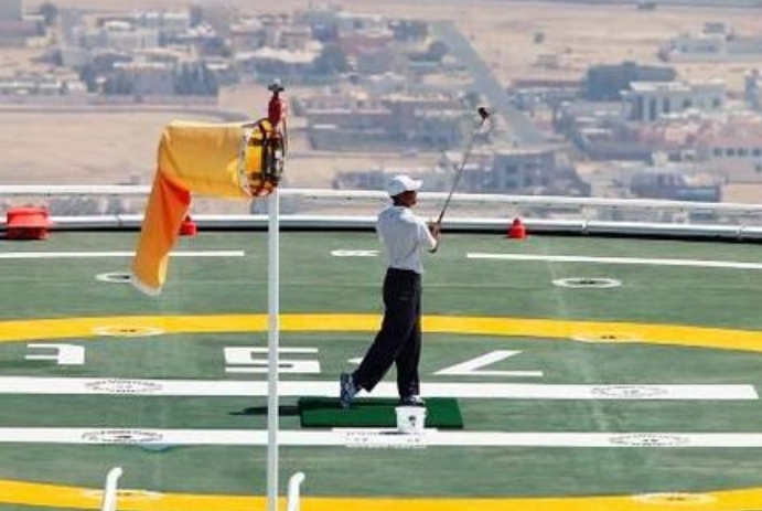 The American golfer Tiger Woods hits a few shots from the helicopter pad